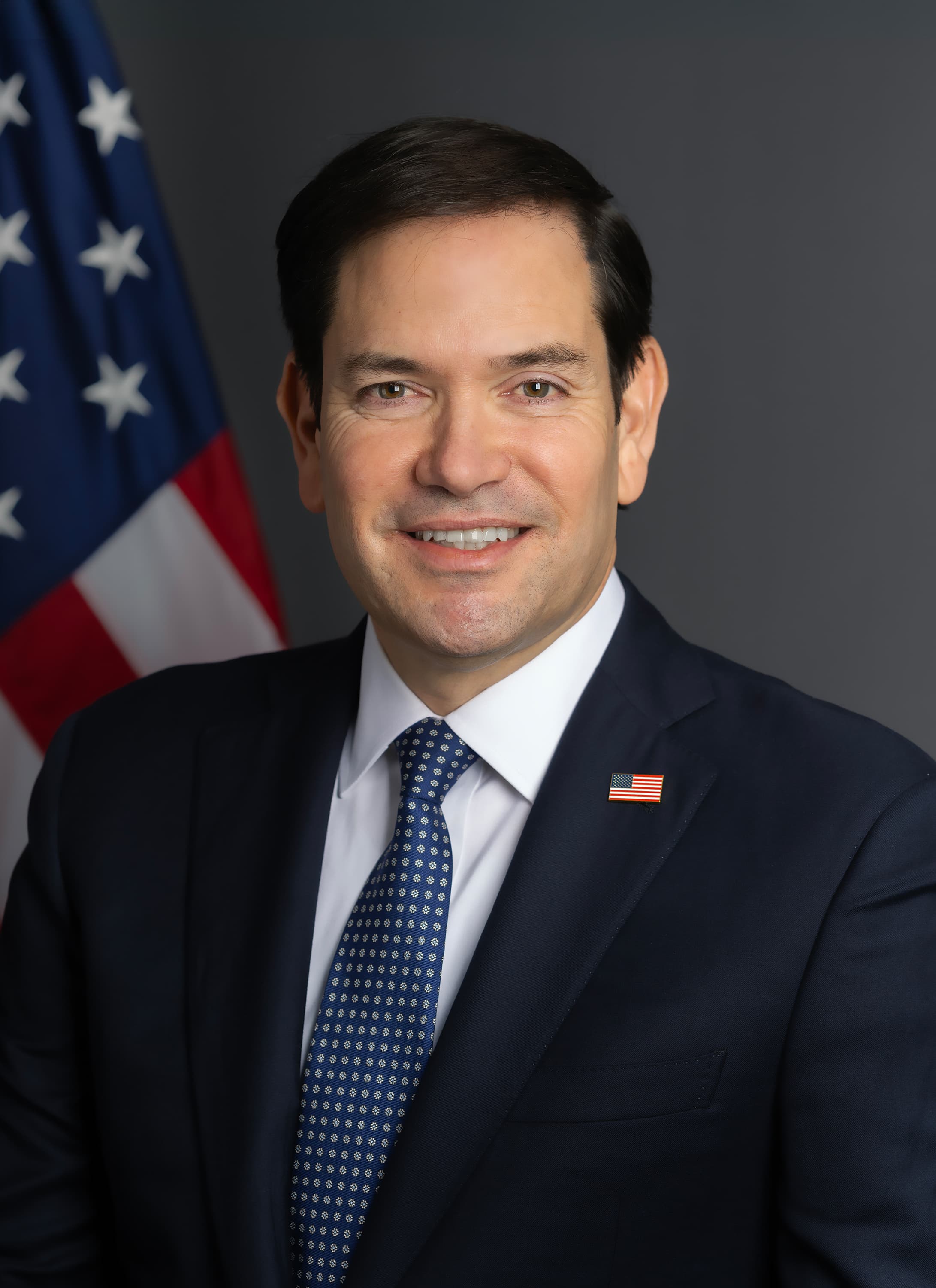 Official January 2025 portrait of Secretary of State Marco Rubio, with the United States flag.