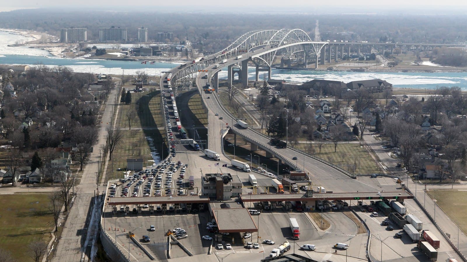 The arched spans of the Blue Water Bridge between Port Huron, Michigan, and Point Edward, Ontario, above the border crossing plaza with trucks, in a 2011 archive photo.