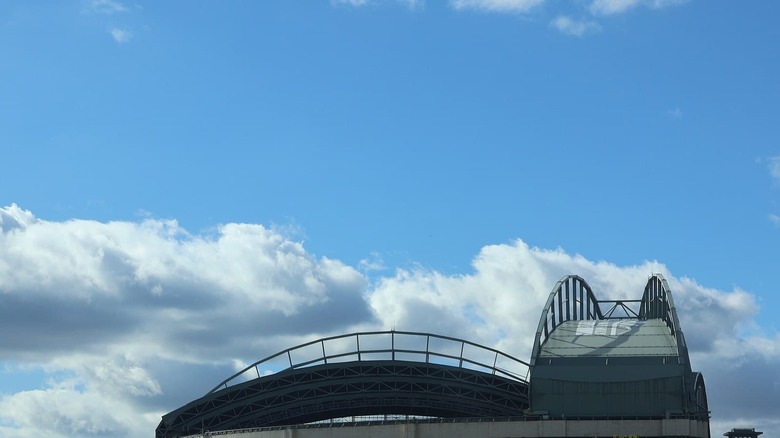 Exterior of American Family Field in Milwaukee under a partly cloudy sky.
