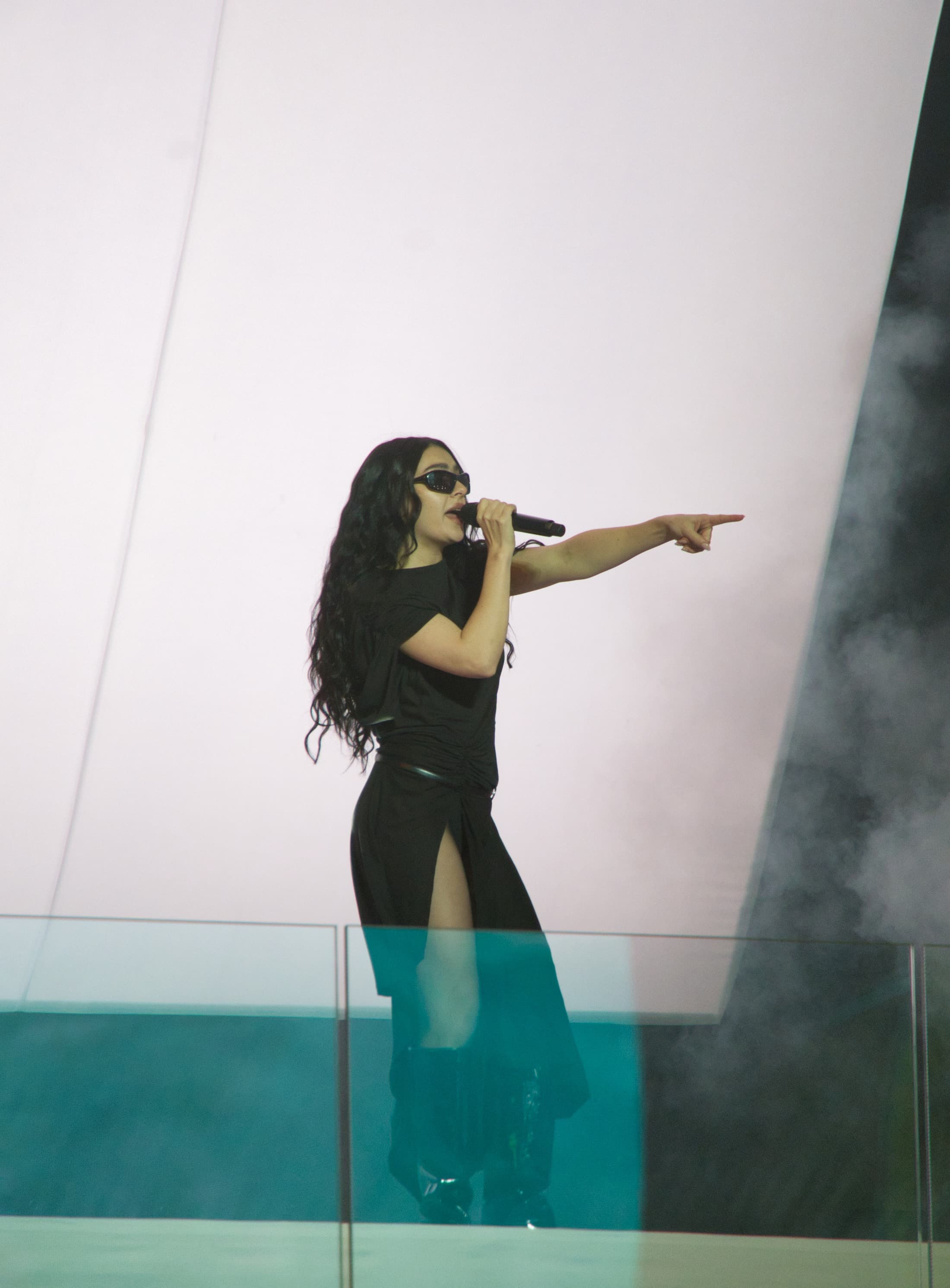Charli XCX performing on an outdoor stage in Times Square in 2024.