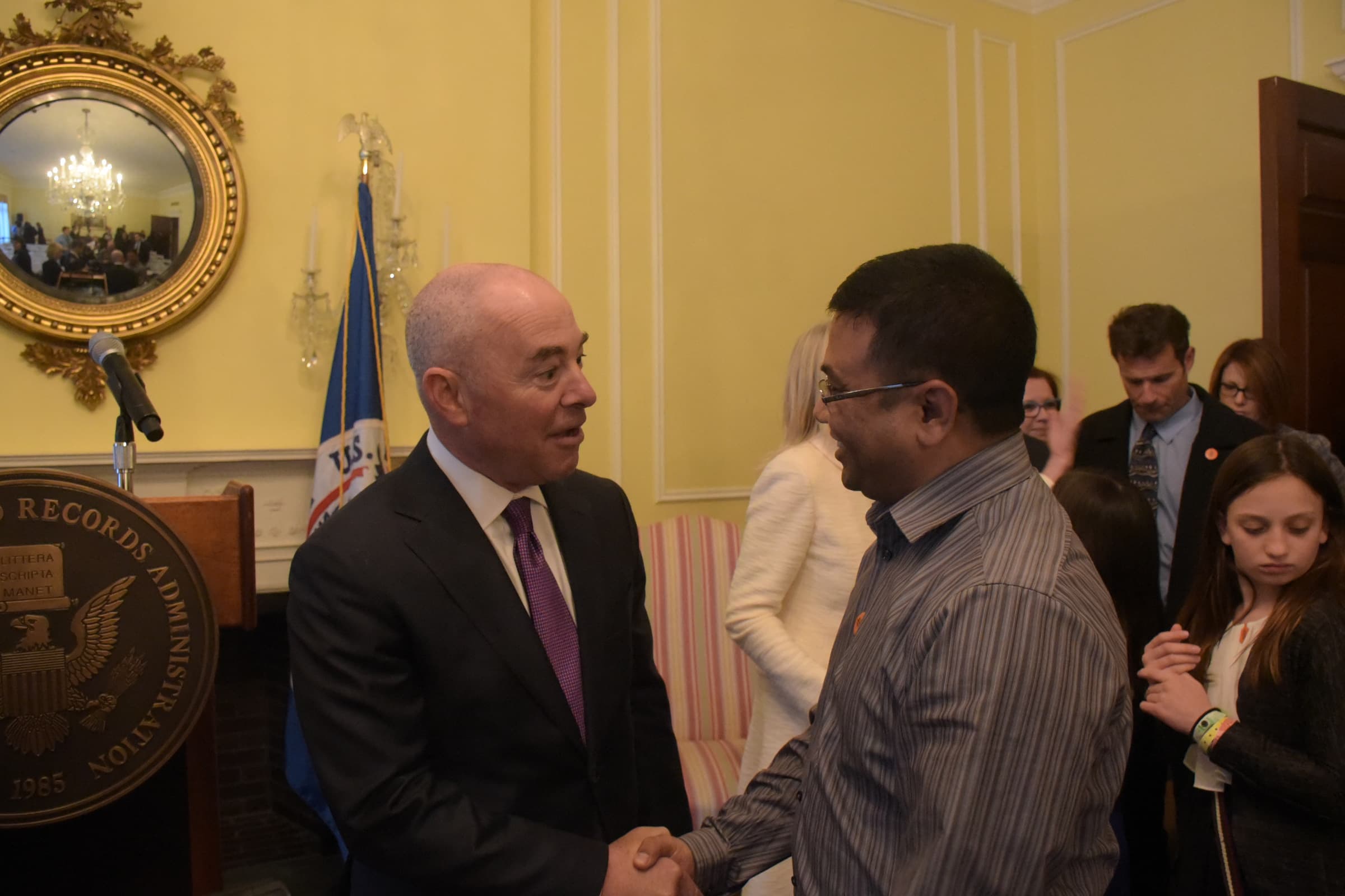 Alejandro Mayorkas greets a participant at a naturalization ceremony in the National Archives in 2016.